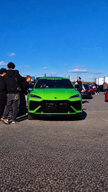 Lime green Lamborghini Urus facing the camera on the lot.